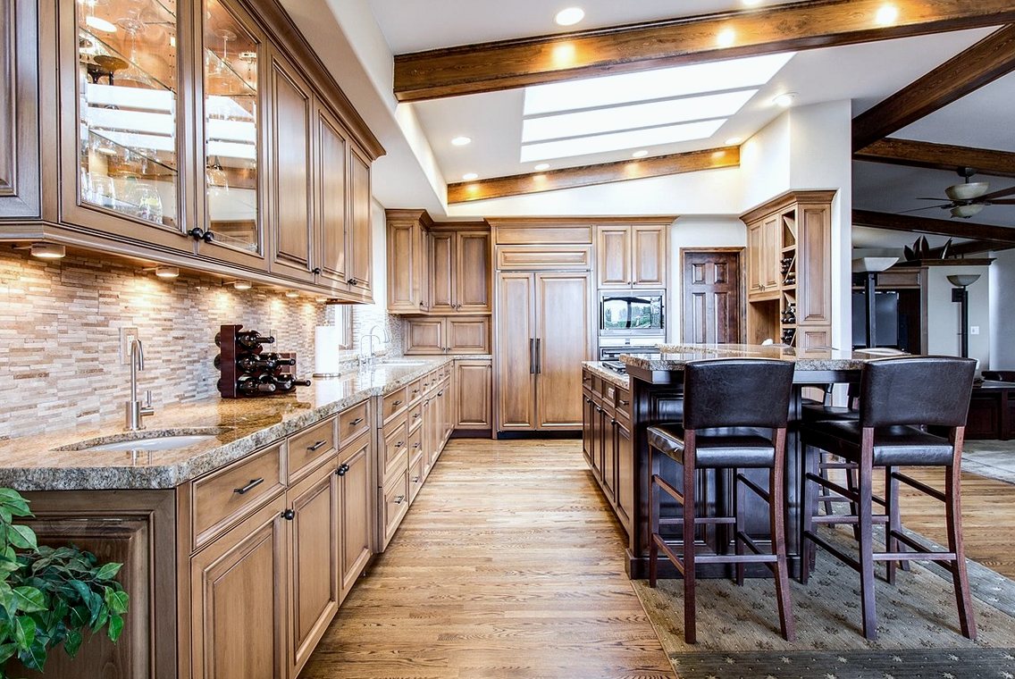 Oak fitted kitchen with granite worktops, mosaic splashback tiles and wood flooring